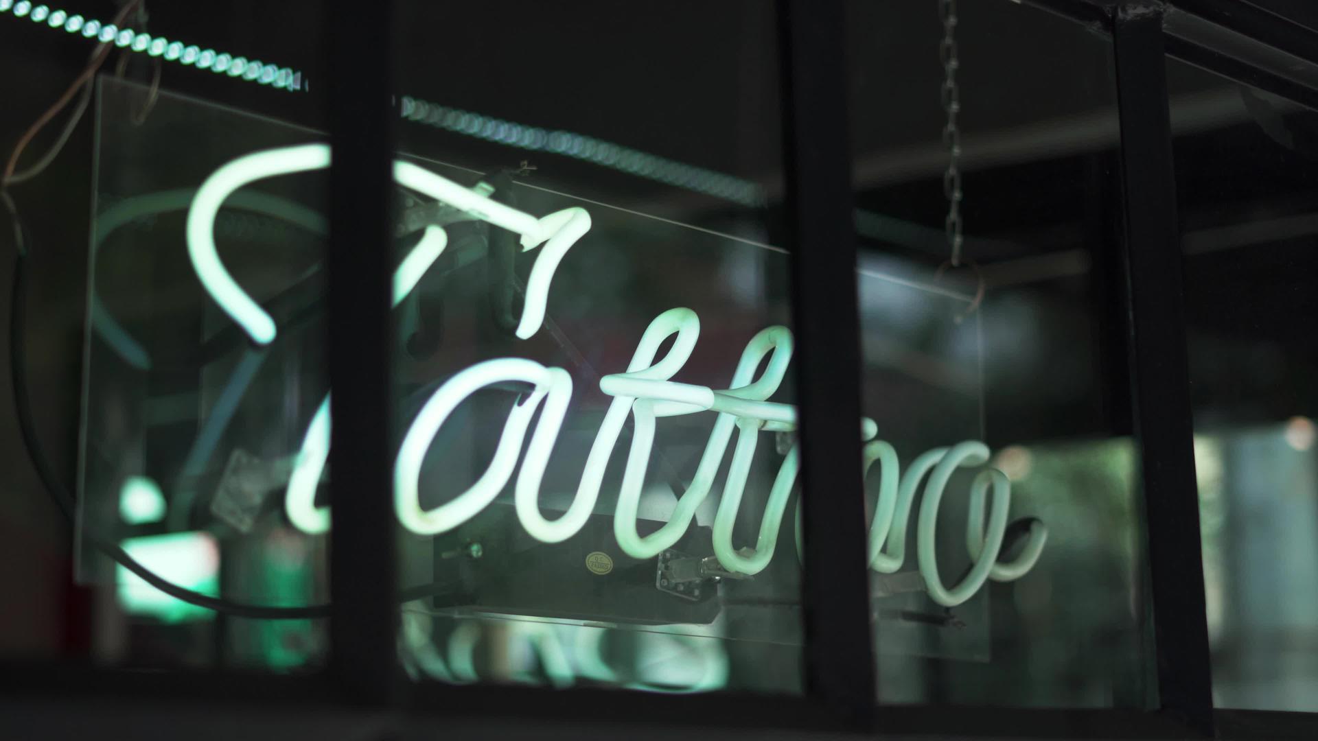 蓝色纹身灯符号在理发店和纹身工作室的窗户上视频的预览图