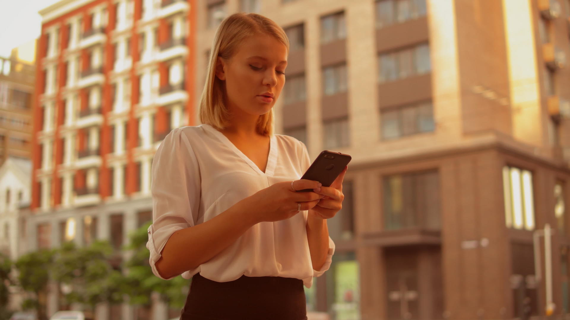 成功的女商人在街上使用智能手机视频的预览图