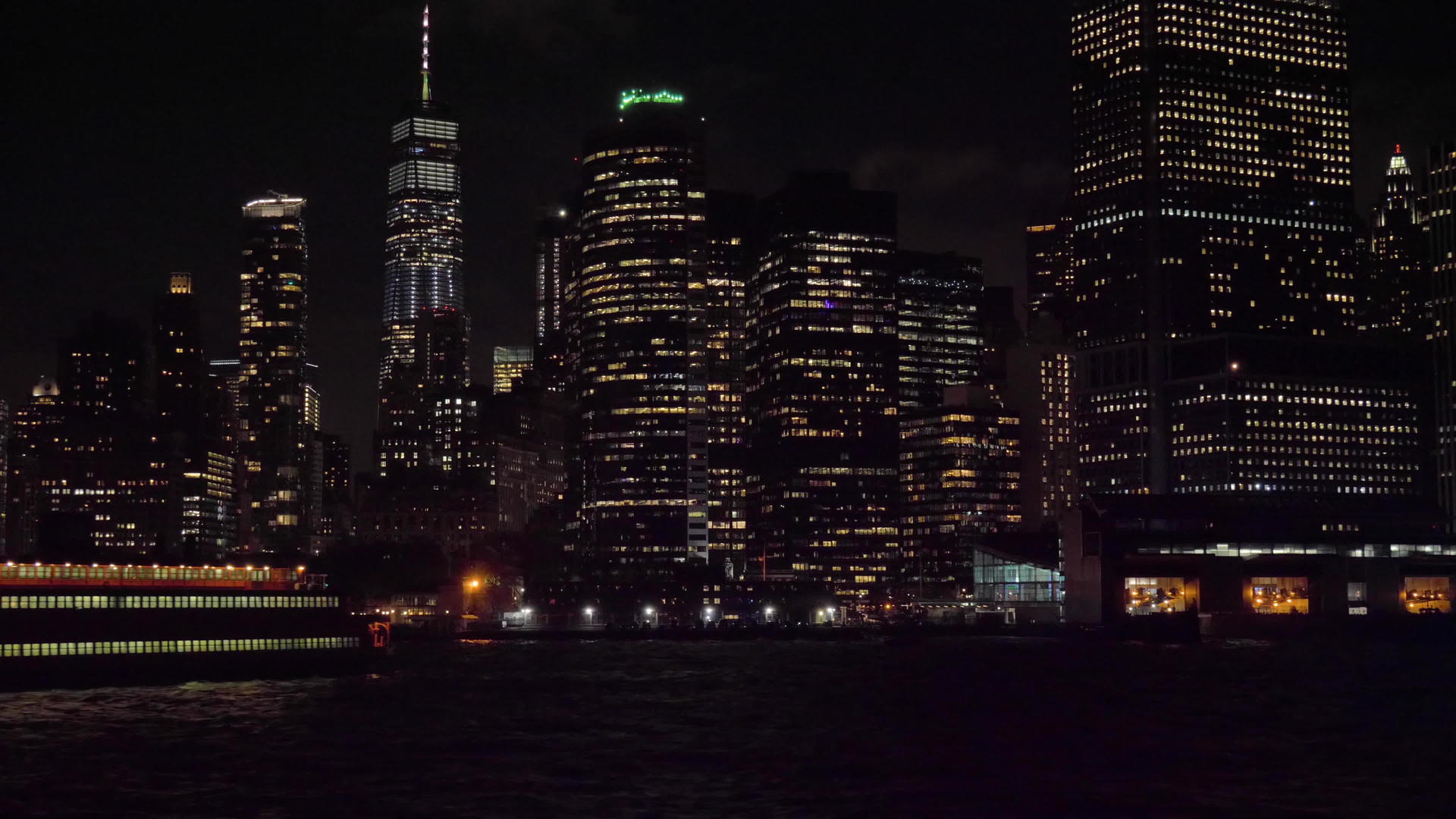 晚上纽约船上的曼哈顿城市天线从水中看摄像机向上倾斜视频的预览图