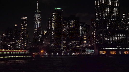 晚上纽约船上的曼哈顿城市天线从水中看摄像机向上倾斜视频的预览图