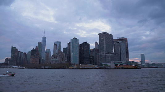 曼哈顿的城市风景在一个阴云的夜晚纽约新城从船上看视频的预览图