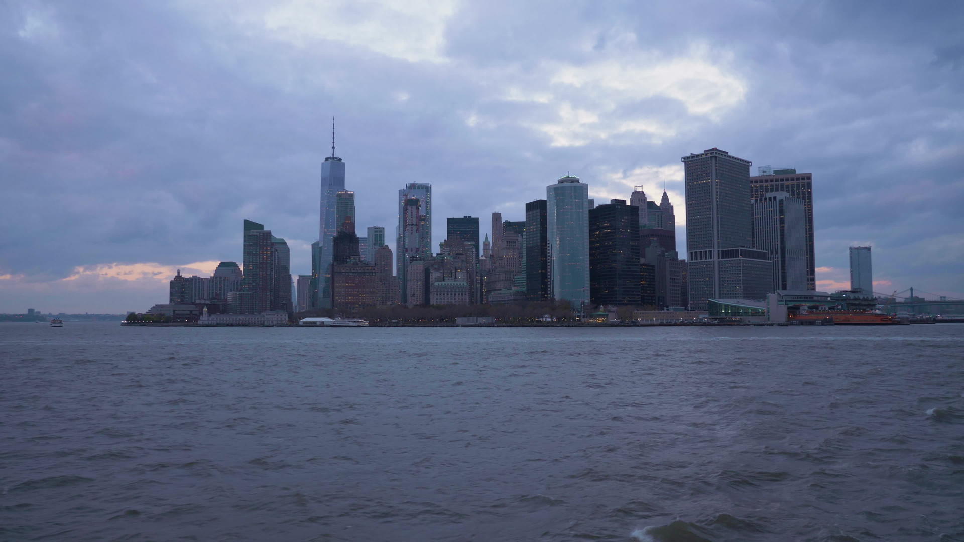 在多云的夜晚曼哈顿市的天际线纽约市从船上查看纽约市视频的预览图