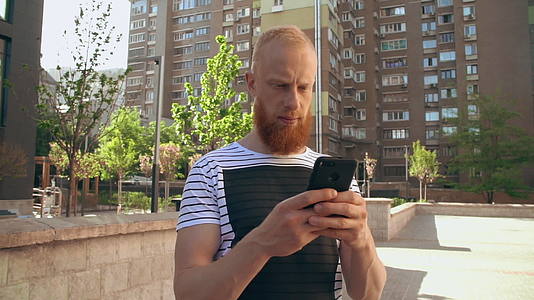 男人在智能手机上浏览互联网视频的预览图