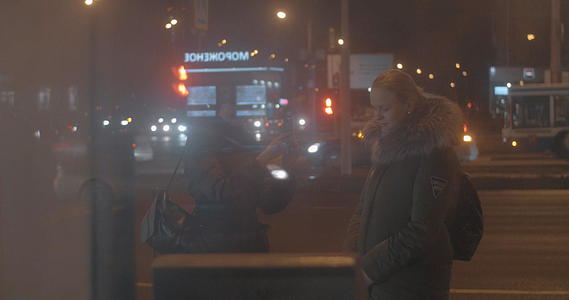 朋友们在夜市等公共汽车时拍手机照片夜市等公交车视频的预览图