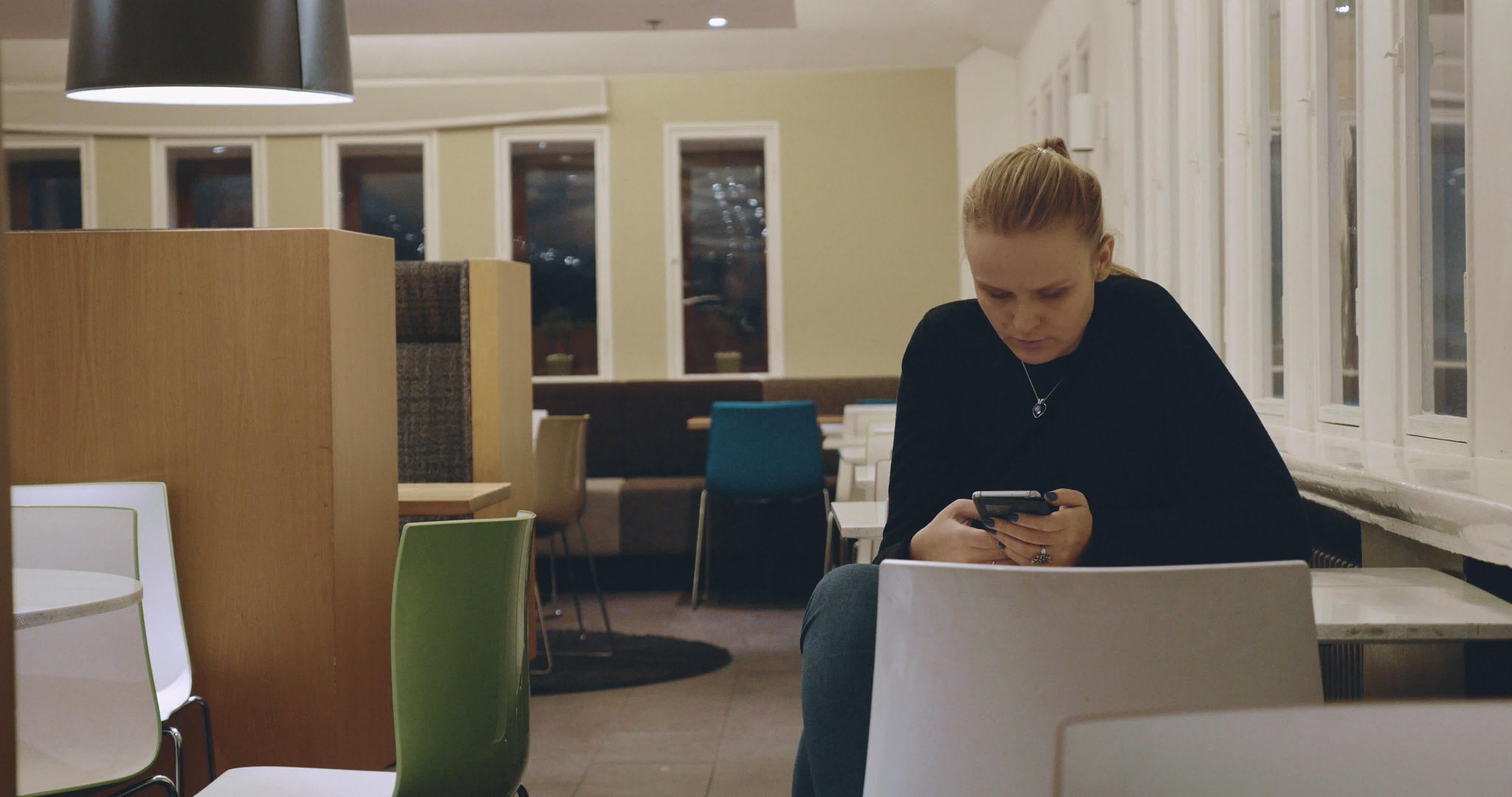 独自坐在咖啡馆和手机上的女性视频的预览图