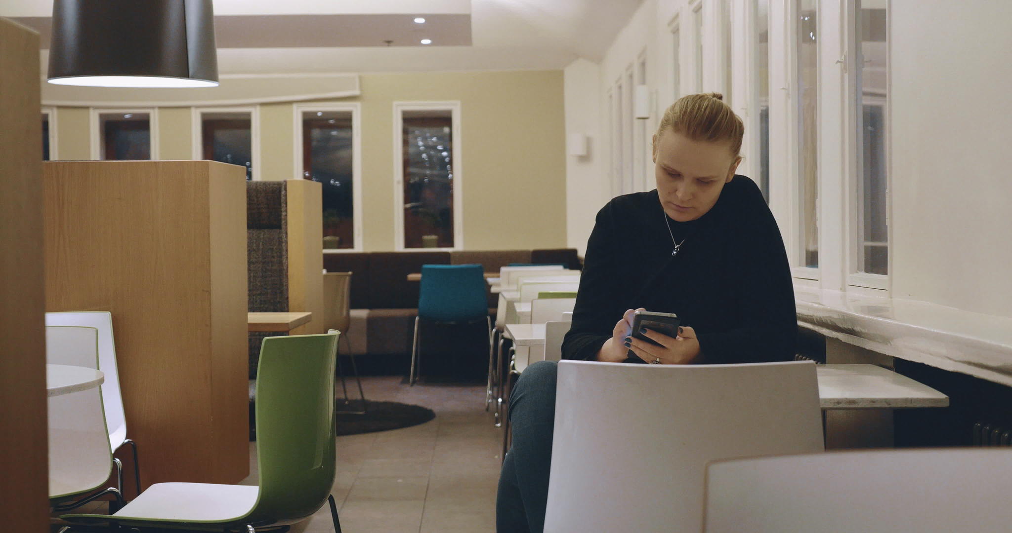 金发金发女郎在咖啡馆用手机路过视频的预览图
