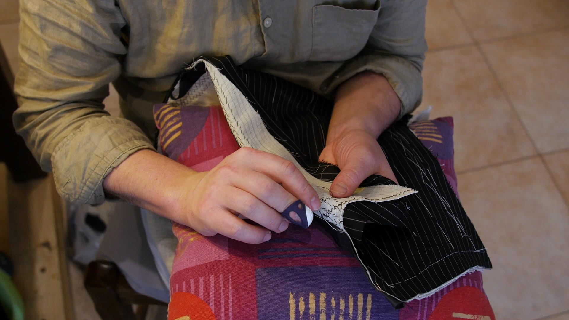 英俊的裁缝女裁缝用手垫缝制西装、翻领和翻领视频的预览图