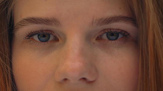 在镜头上观看女性蓝眼睛的肖像视频的预览图