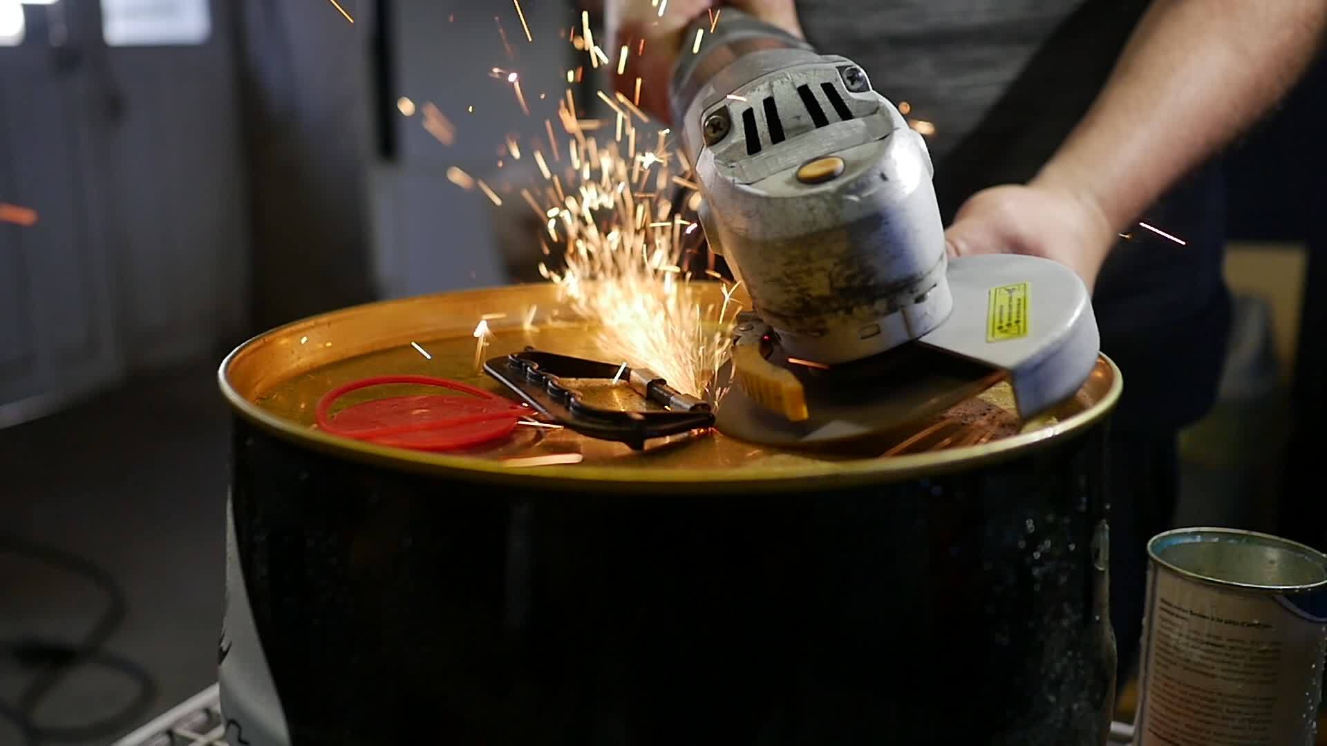 角磨机的慢动作和金属桶上的火花可以DIY项目男子在视频的预览图