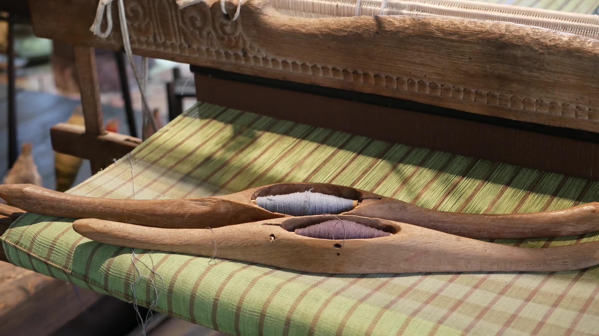 木制穿梭机将自然线放置在编织的织物上视频的预览图