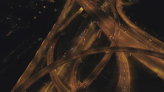 复杂的道路交叉口和汽车交通无人机在夜间照明中向后飞行视频的预览图