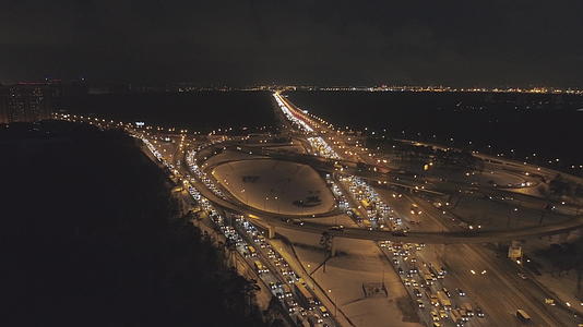 冬夜照明复杂的高速公路交叉口和汽车交通堵塞无人机视频的预览图
