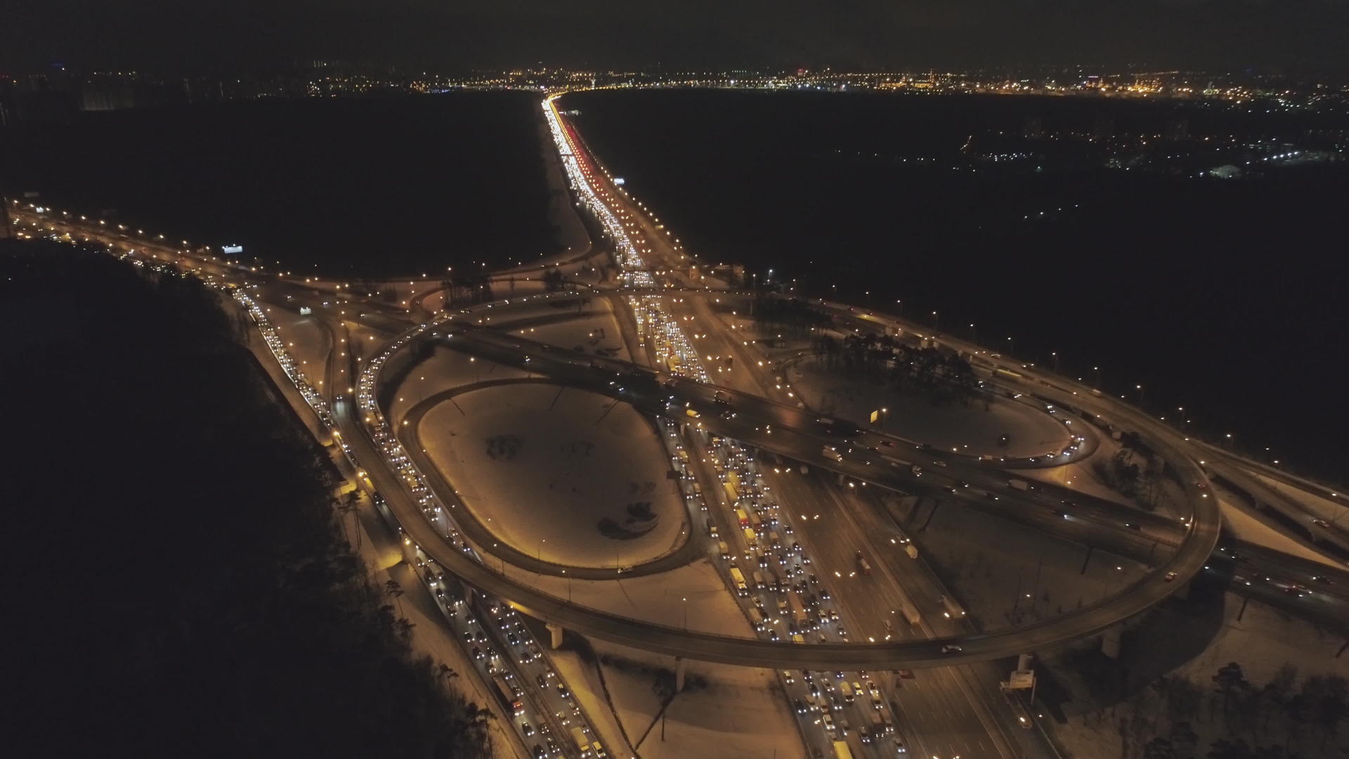 冬夜照明复杂的高速公路交叉口和汽车交通堵塞无人机向前移动视频的预览图