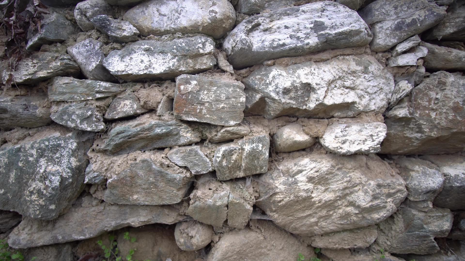 一座古老的石墙一座被破坏的房子在草地之间旧房子的废墟视频的预览图