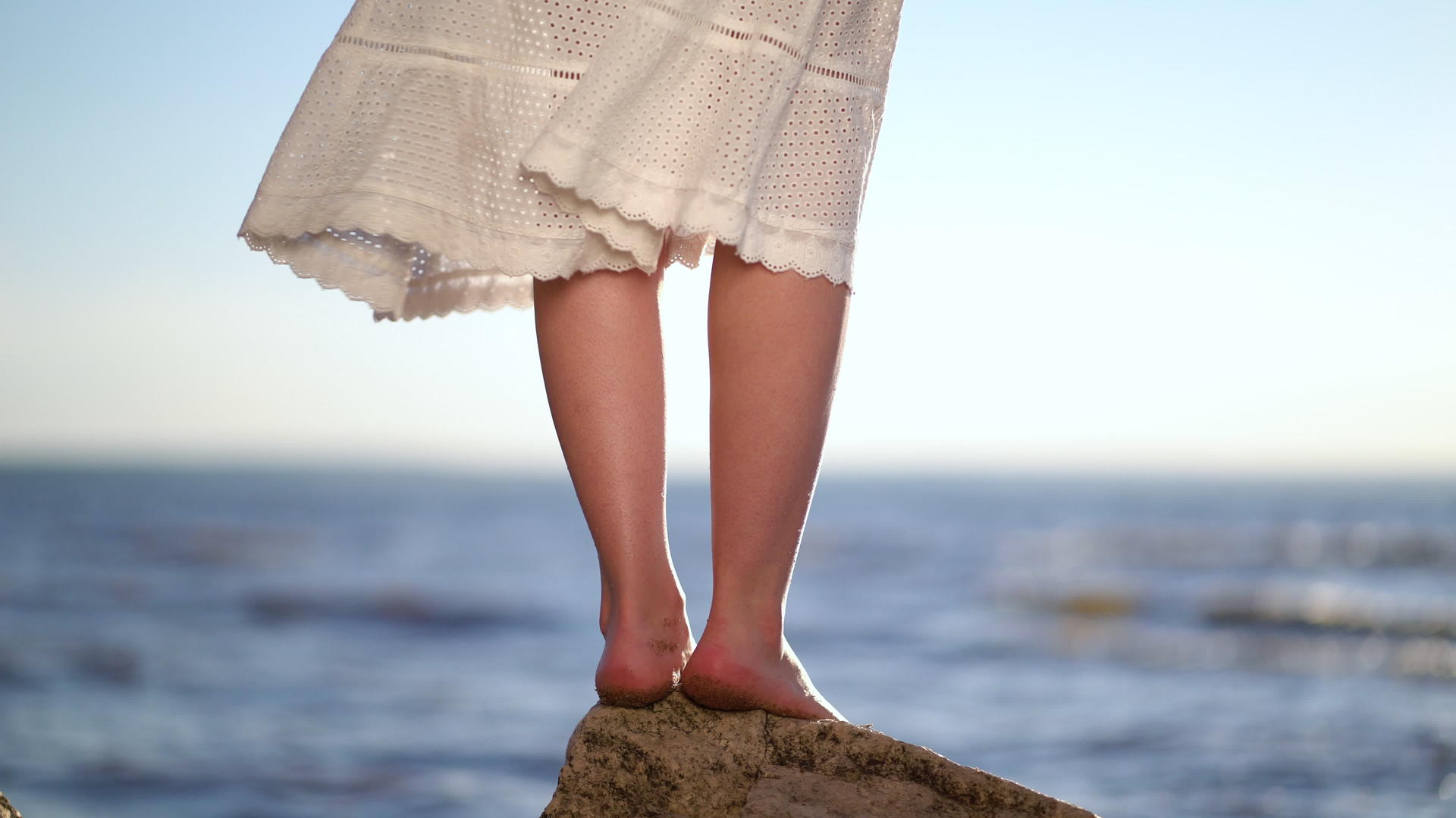 女人的脚站在长凳上的一块石头上海石头海滩上的女人视频的预览图