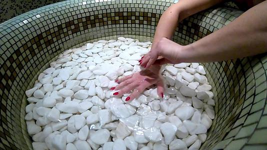 女性手温泉石按摩美容治疗辣椒热石视频的预览图