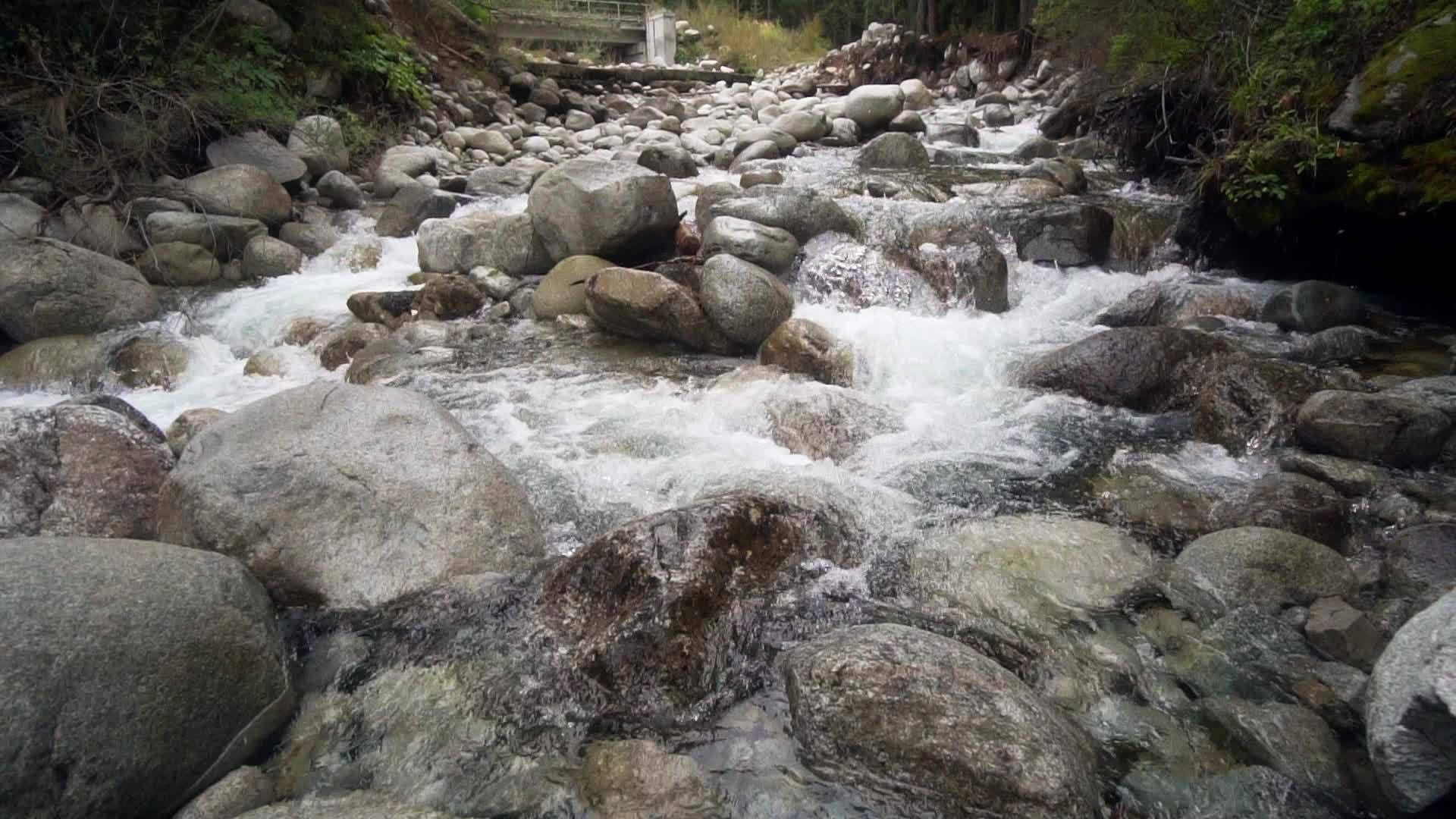 山川流动小水落下弯曲圆石岩缓慢移动视频的预览图