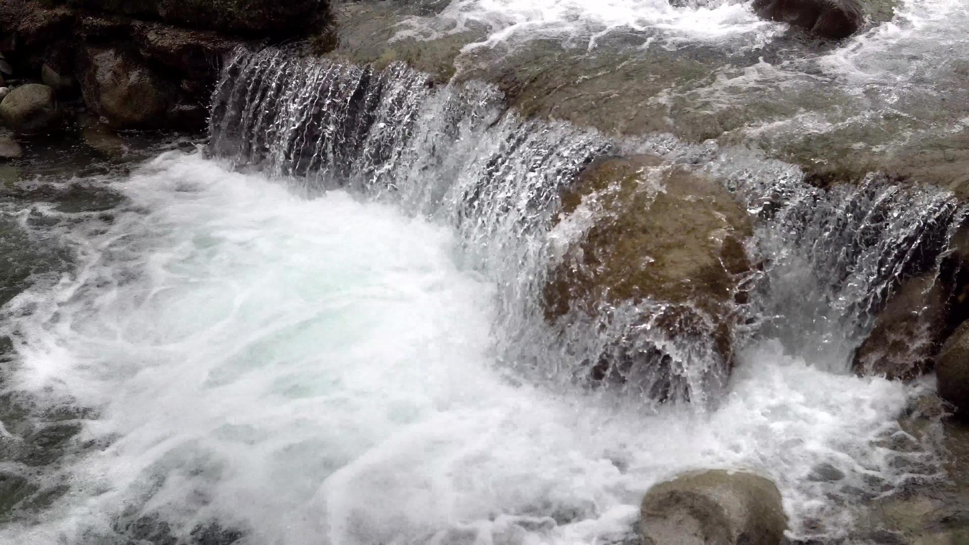 清澈的山川和溪流滴落并弯曲圆形石岩视频的预览图