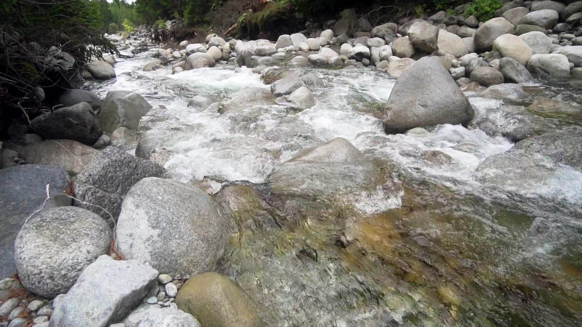 山川流动小水落下弯曲圆石岩缓慢移动视频的预览图