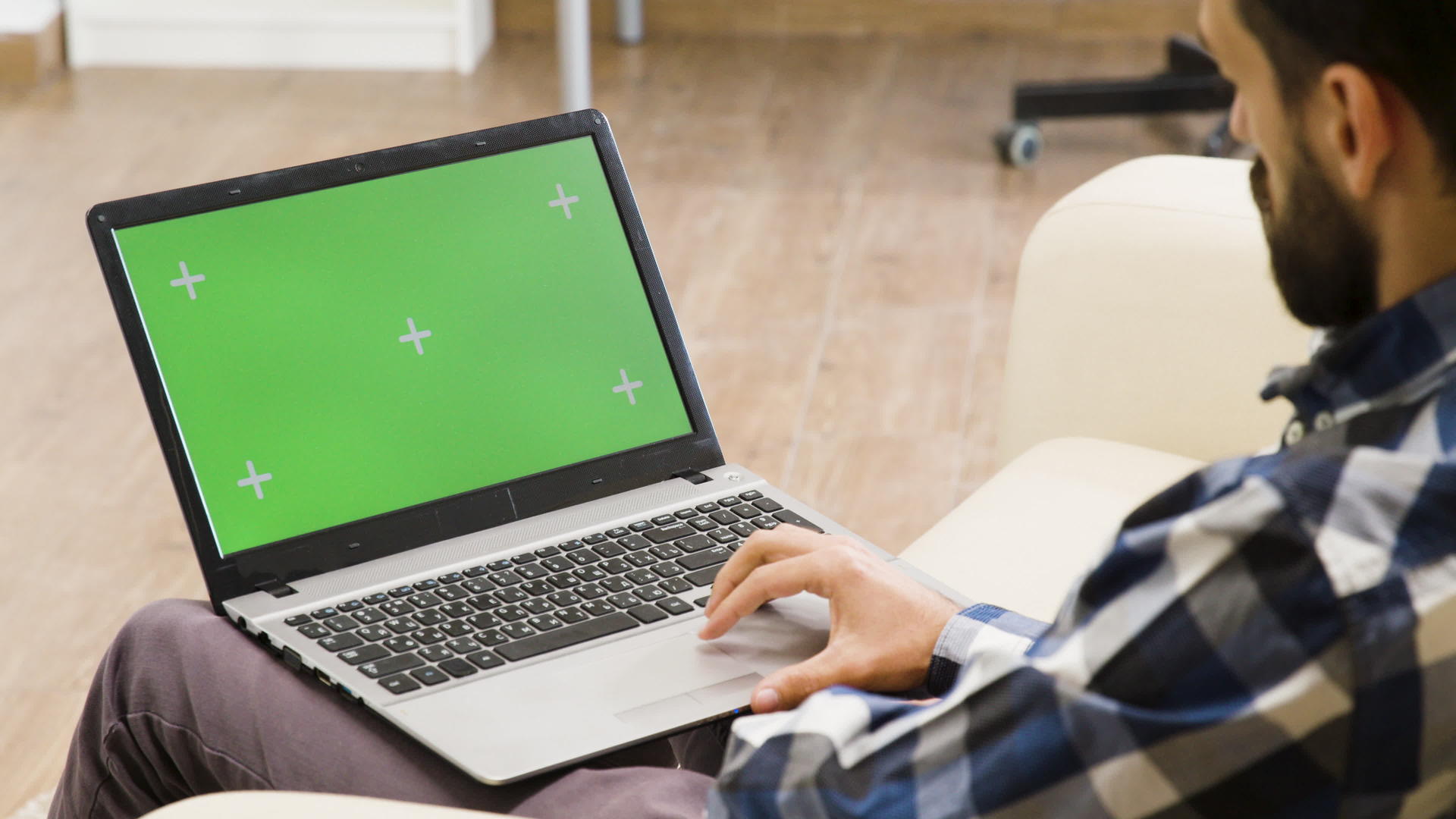 人们看着沙发上的绿色屏幕笔记本电脑视频的预览图