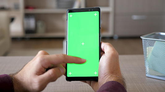 男人们用智能手机和绿色屏幕染色装扮视频的预览图