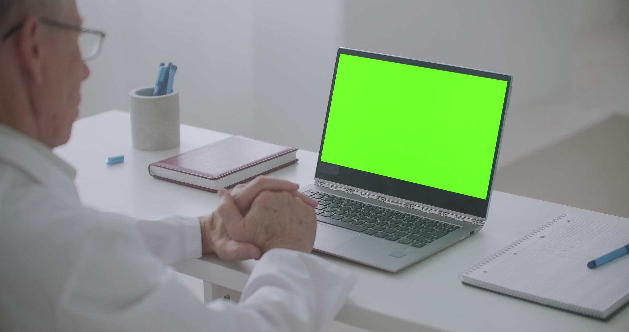 男医生正在查看笔记本电脑的绿色屏幕并在网上传播视频电话视频的预览图