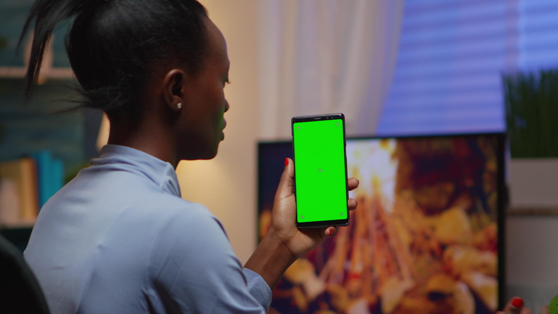 女士们在家里看绿屏智能手机放松笑声视频的预览图