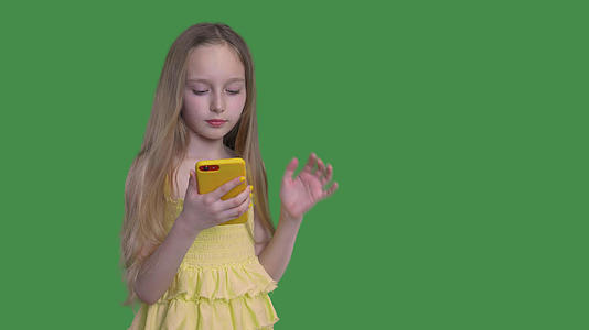 留着长发的女孩正在按下绿色背景浏览手机的笑声视频的预览图