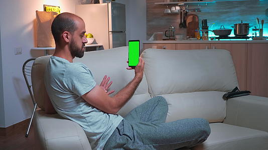 关键人物在智能手机上与朋友交谈用绿屏染色仪显示绿屏视频的预览图