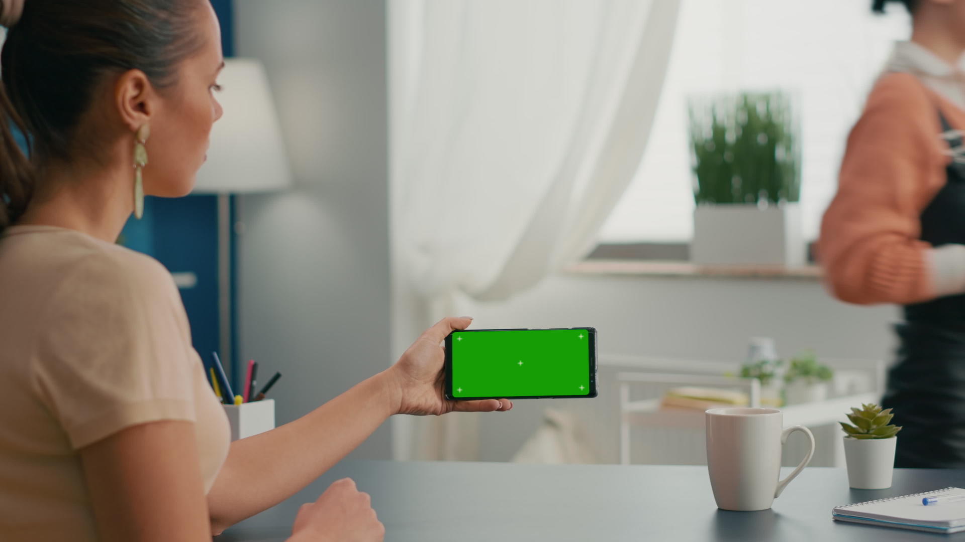 商业女性拥有手机和绿色屏幕染色体视频的预览图