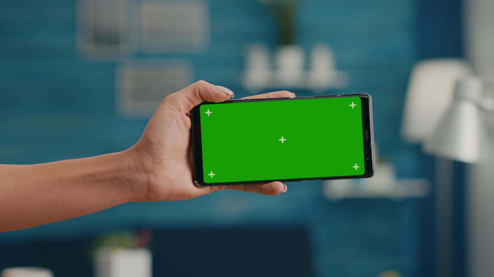 女性手持水平模拟绿屏色键智能手机特写视频的预览图