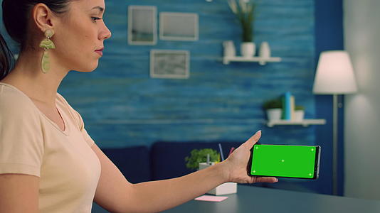 女性手持孤立智能手机安装绿屏caucasian女性视频的预览图