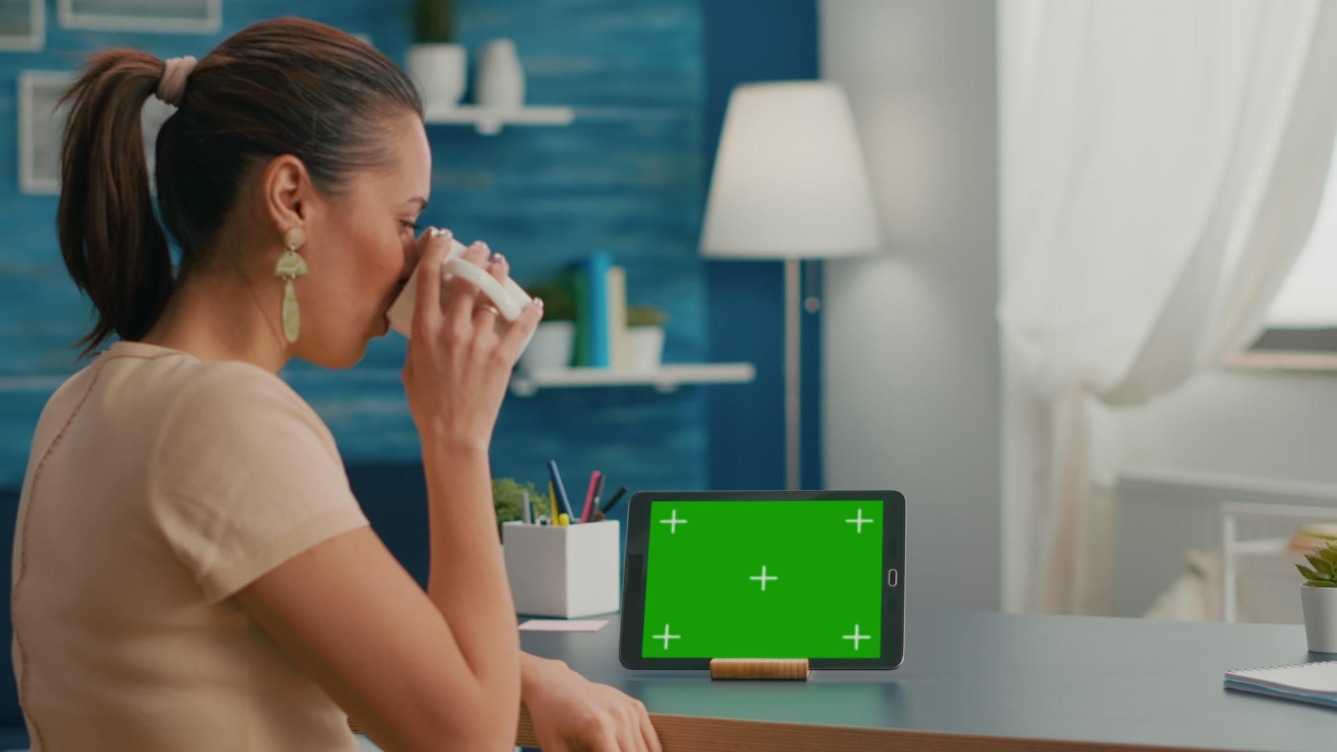 女性在看平板电脑时使用绿色屏幕模拟视频的预览图