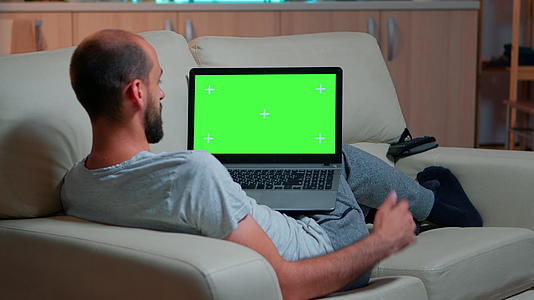 专注的人寻找笔记本电脑模拟绿色屏幕铬钥匙视频的预览图