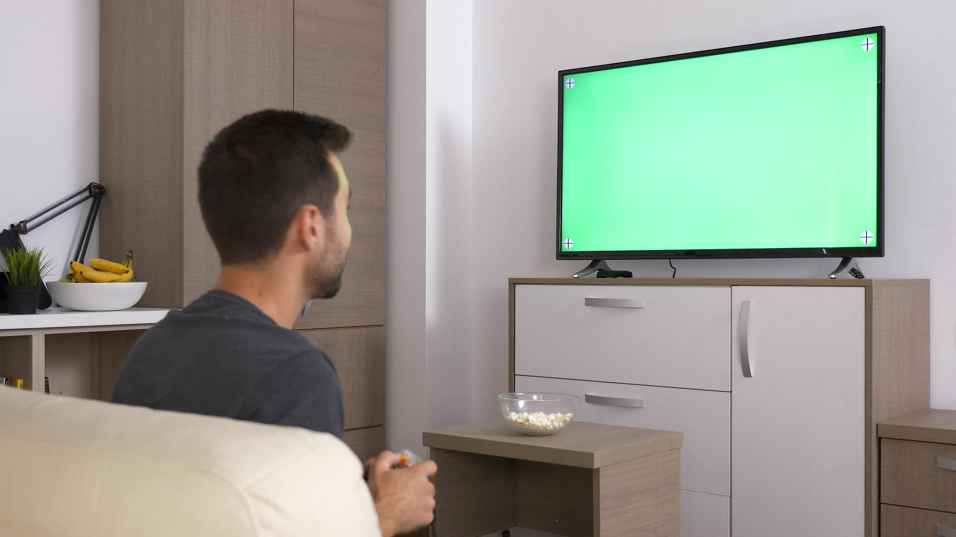 男人在大等离子电视的绿色模拟屏幕前在控制台玩电子游戏视频的预览图