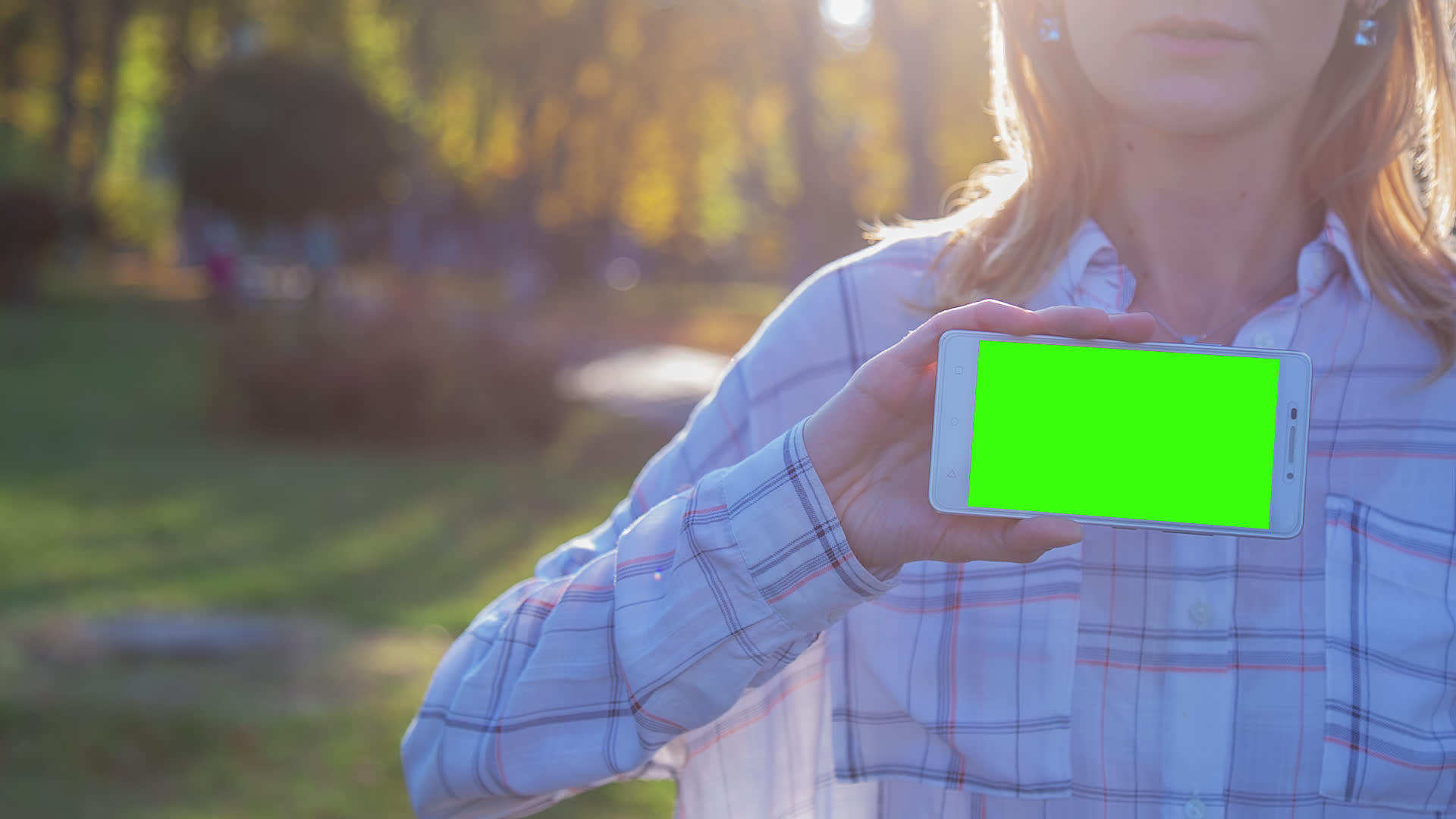 拥有智能手机和绿色屏幕的年轻女性留在城市广场视频的预览图