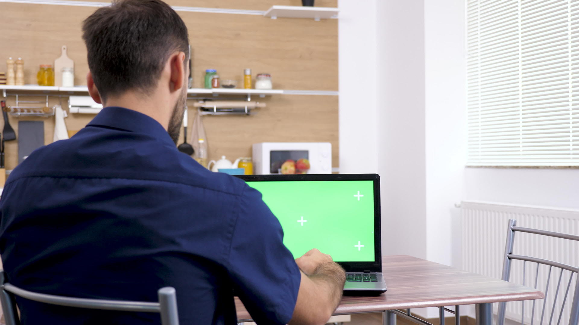 男人用绿屏染色体模拟笔记本电脑打字视频的预览图