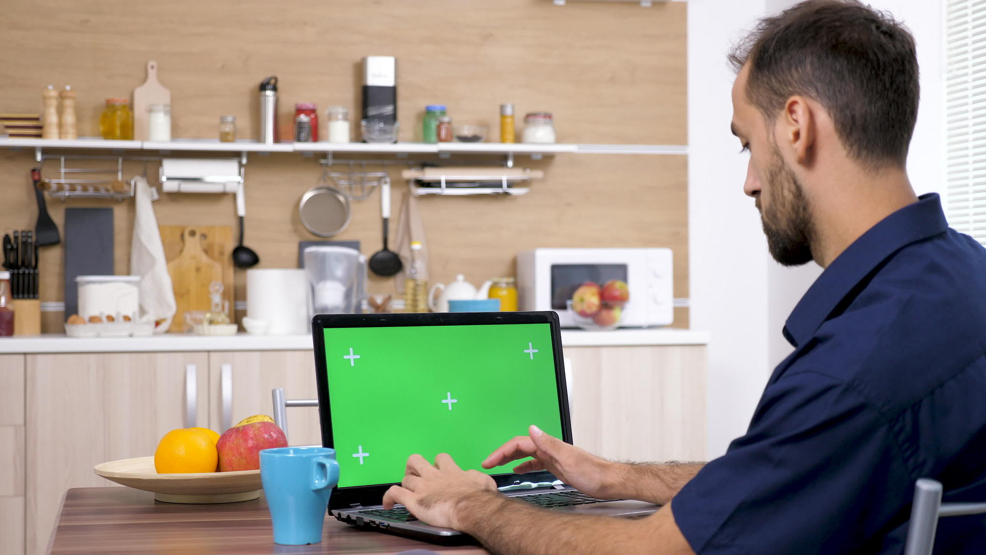 男人在厨房的桌子上喝咖啡打电脑打字视频的预览图
