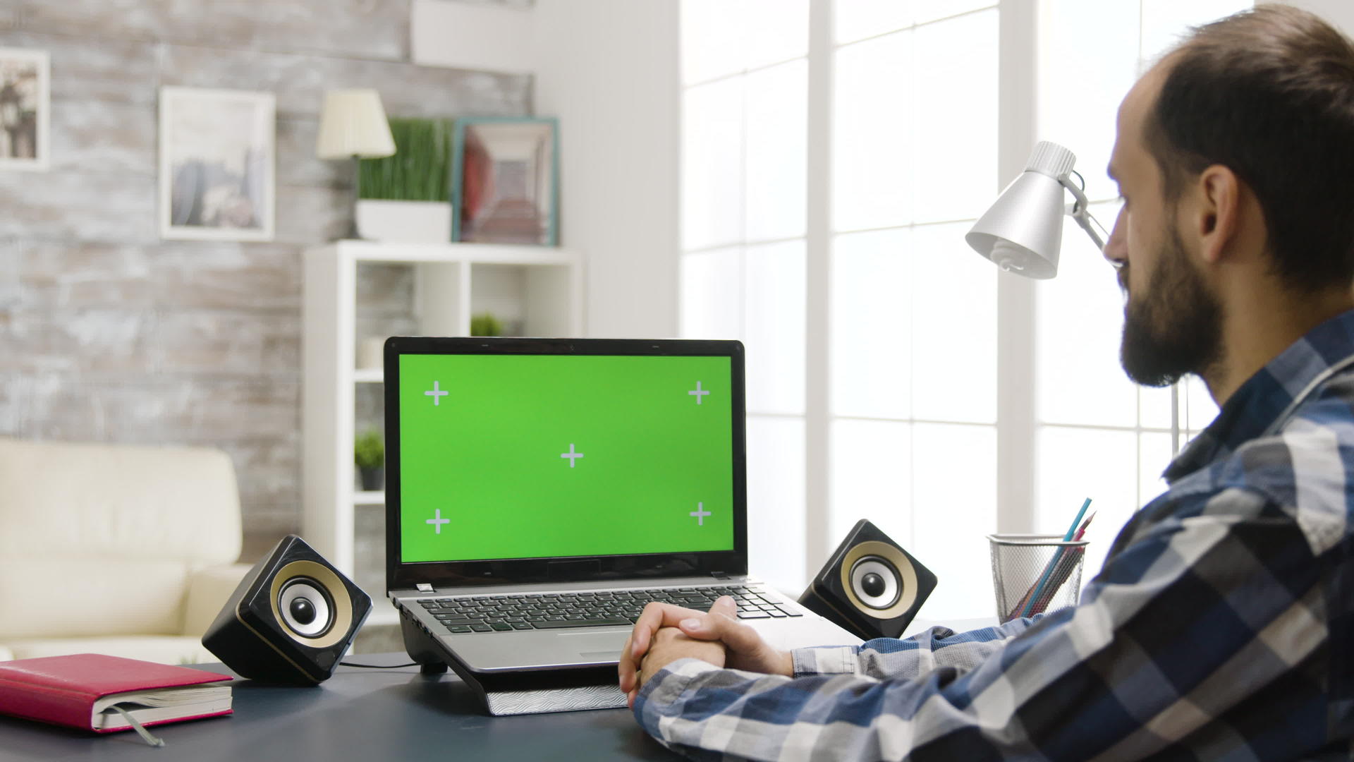 用绿色屏幕看笔记本电脑的人的镜头放大肩膀视频的预览图