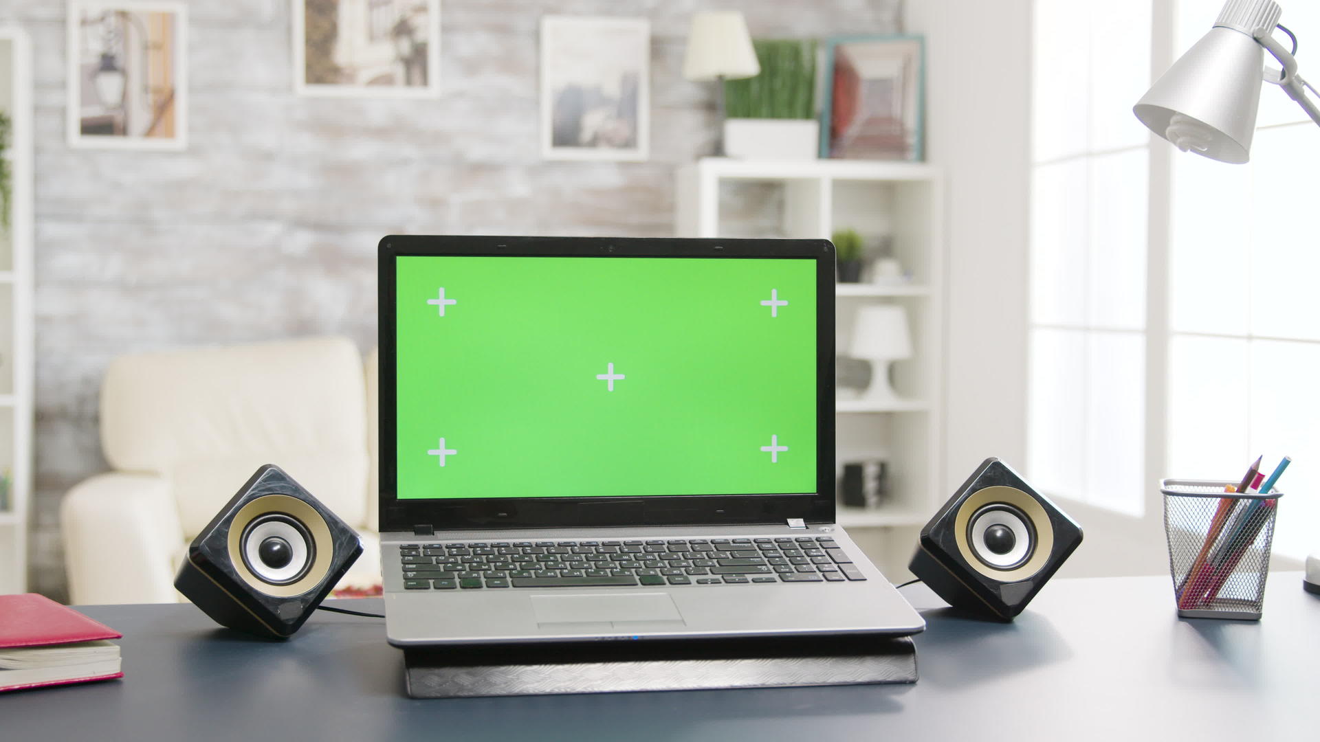 桌子上有明亮明亮的客厅空间中的绿色笔记本电脑视频的预览图