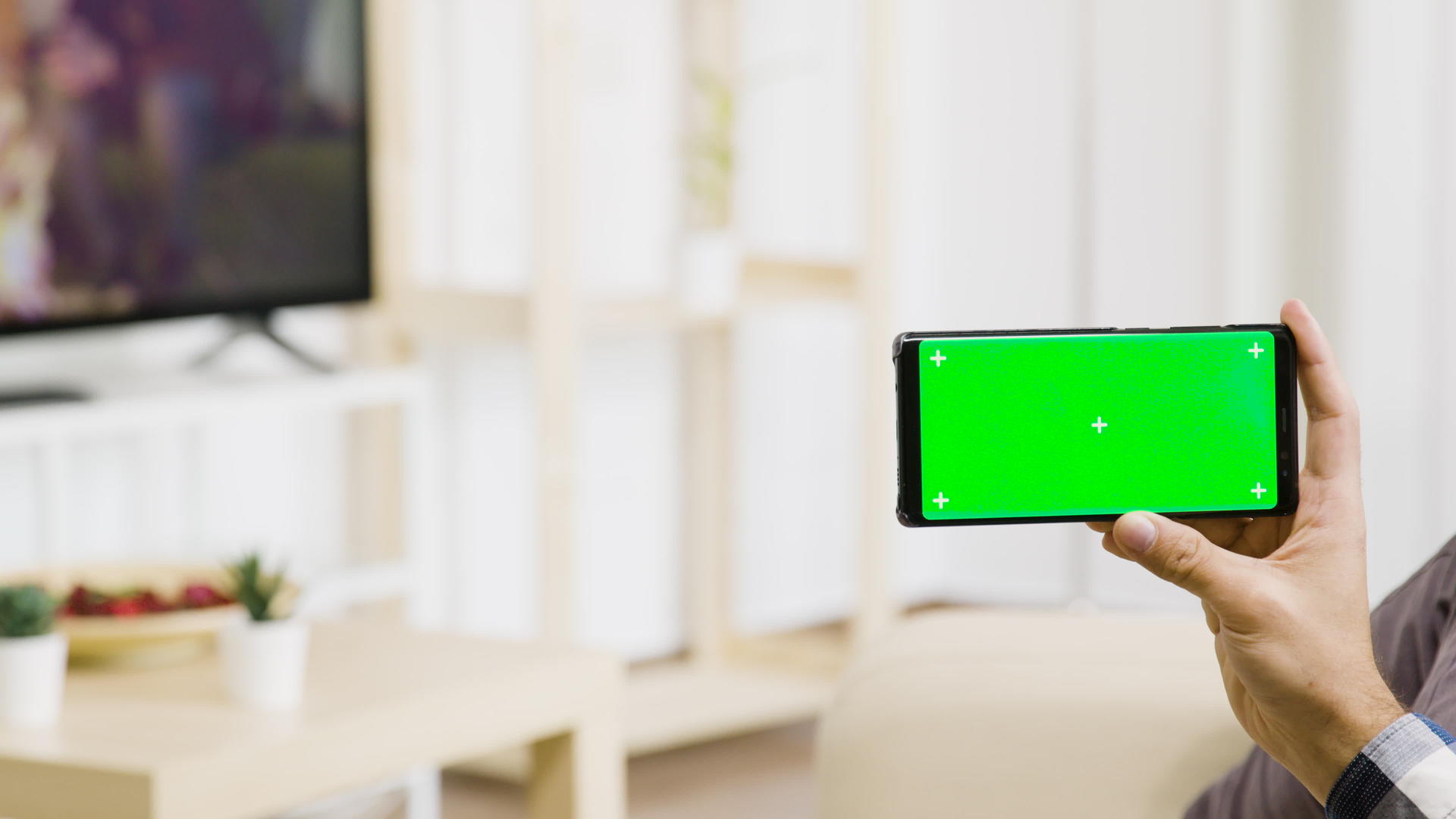 手持绿色屏幕电话在明亮明亮的生活空间视频的预览图