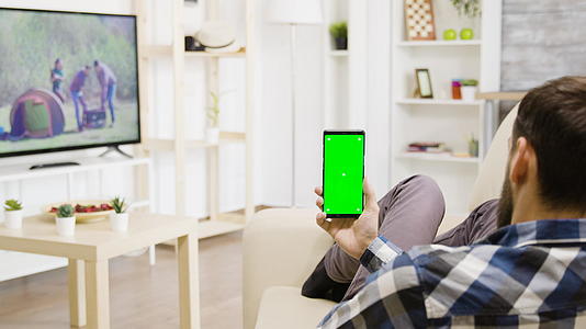 男子垂直握住绿屏电话用绿屏电话视频的预览图