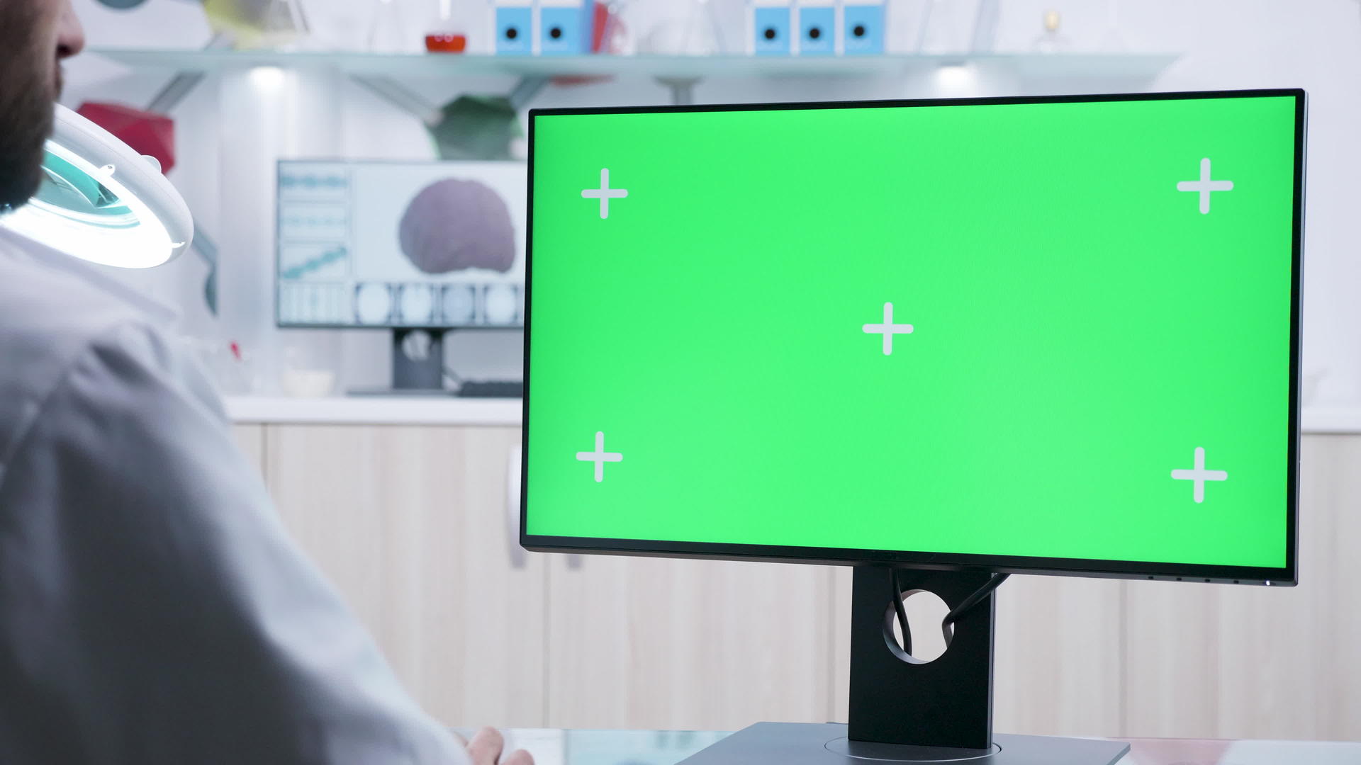 在计算机上工作的医生肩镜头上绿色屏幕模拟静态视频的预览图