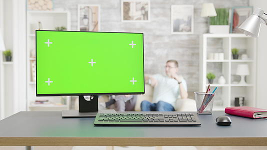 Pc明亮的客厅桌子上有一个孤立的绿色屏幕模型视频的预览图