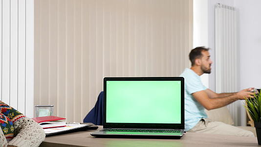 客厅桌子上上有一个绿色屏幕的电脑视频的预览图
