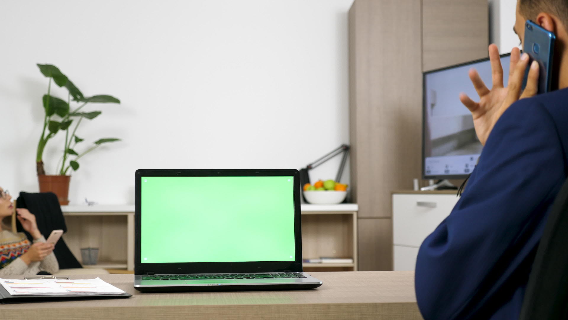 桌子上的电脑有一个绿色的屏幕视频的预览图