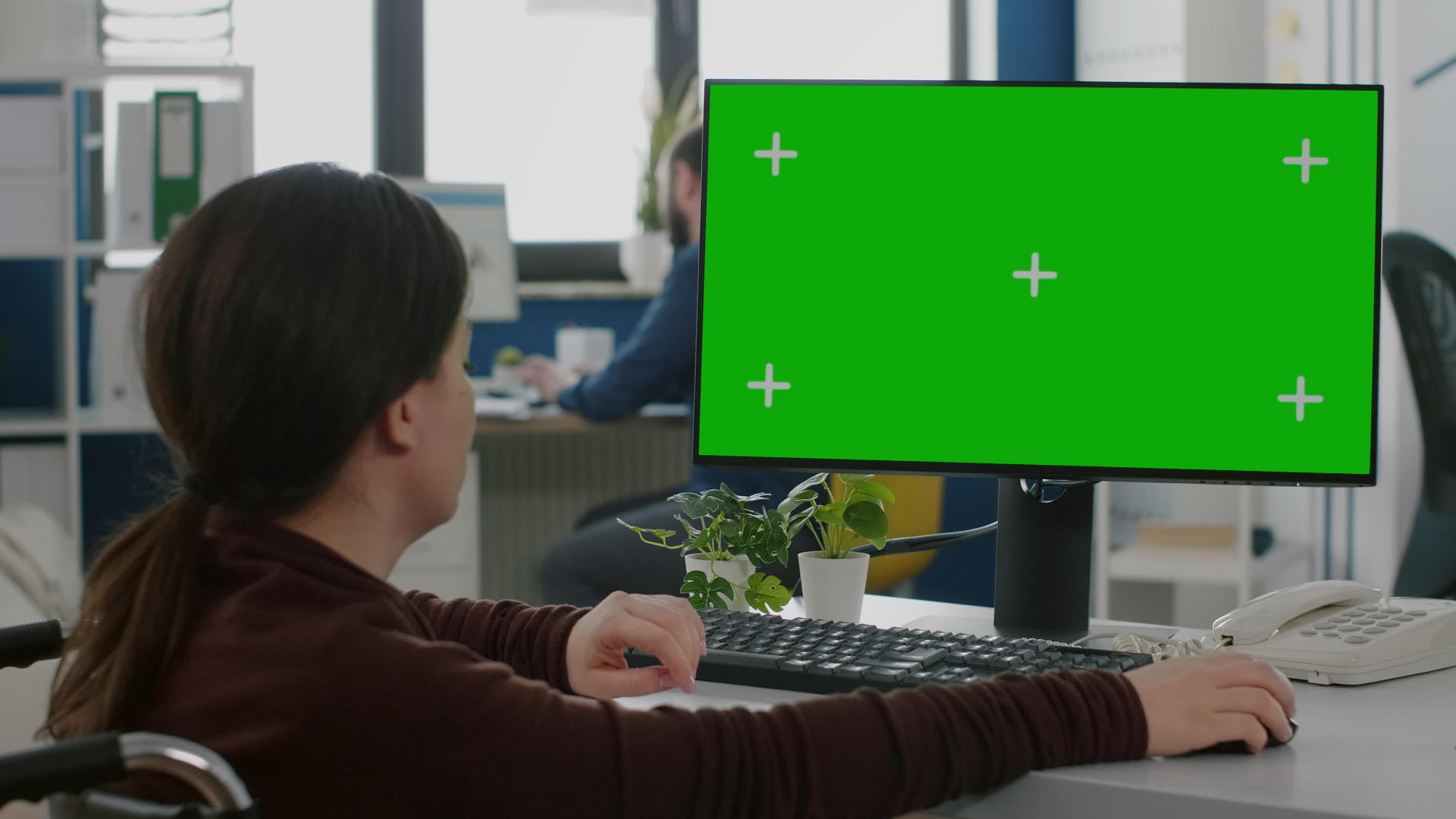 在台式计算机上使用绿色模拟屏幕工作的女性没有固定的动作视频的预览图