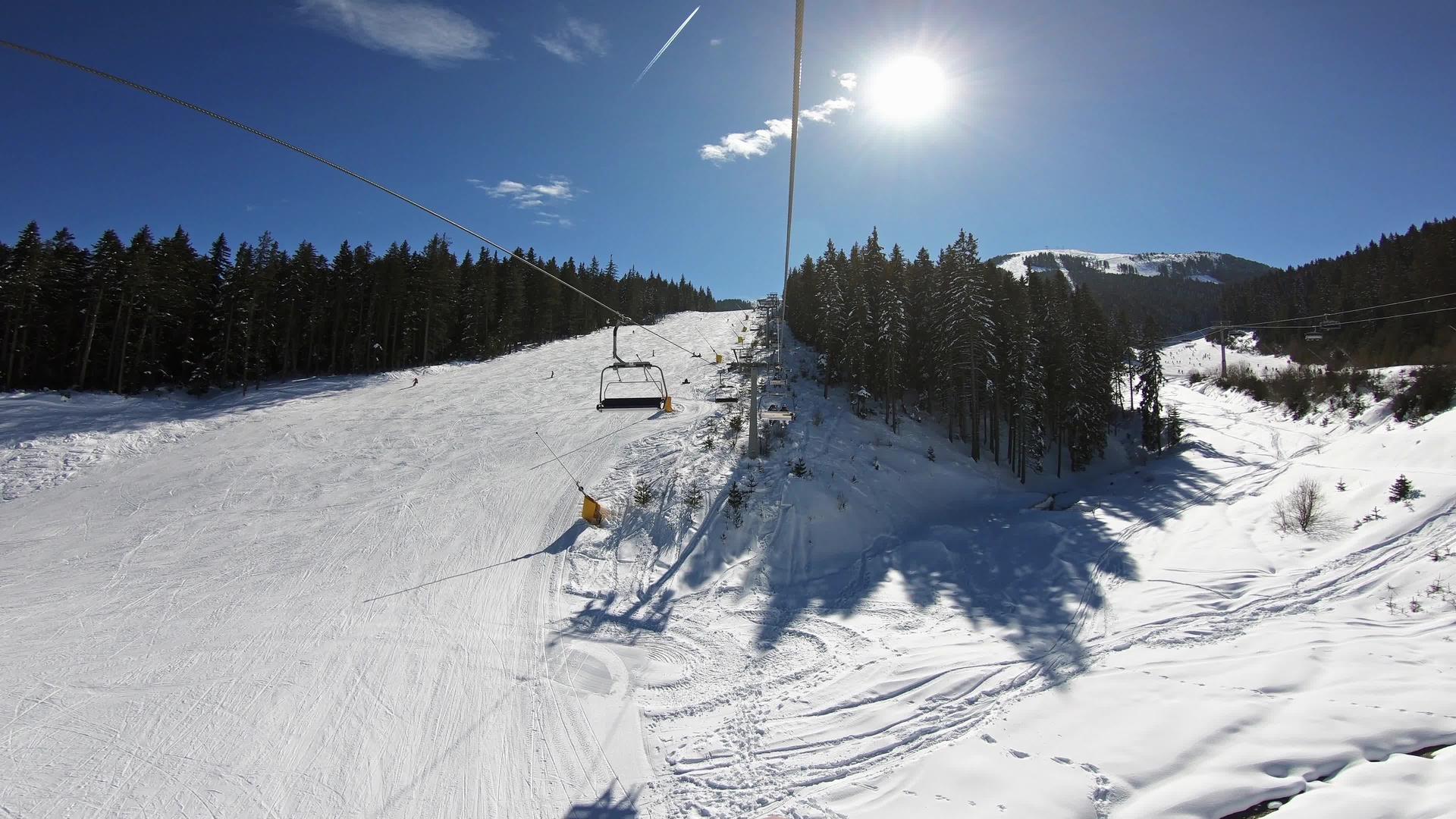 在阳光明媚的一天乘坐高级快速滑雪电梯视频的预览图