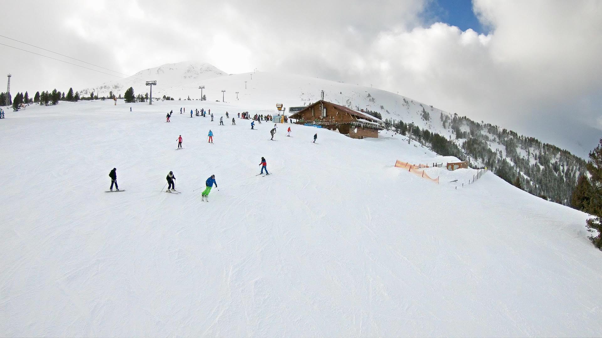 从滑雪的第一个角度来看斜坡上的滑雪机和遥远的雪雪从空中升起视频的预览图