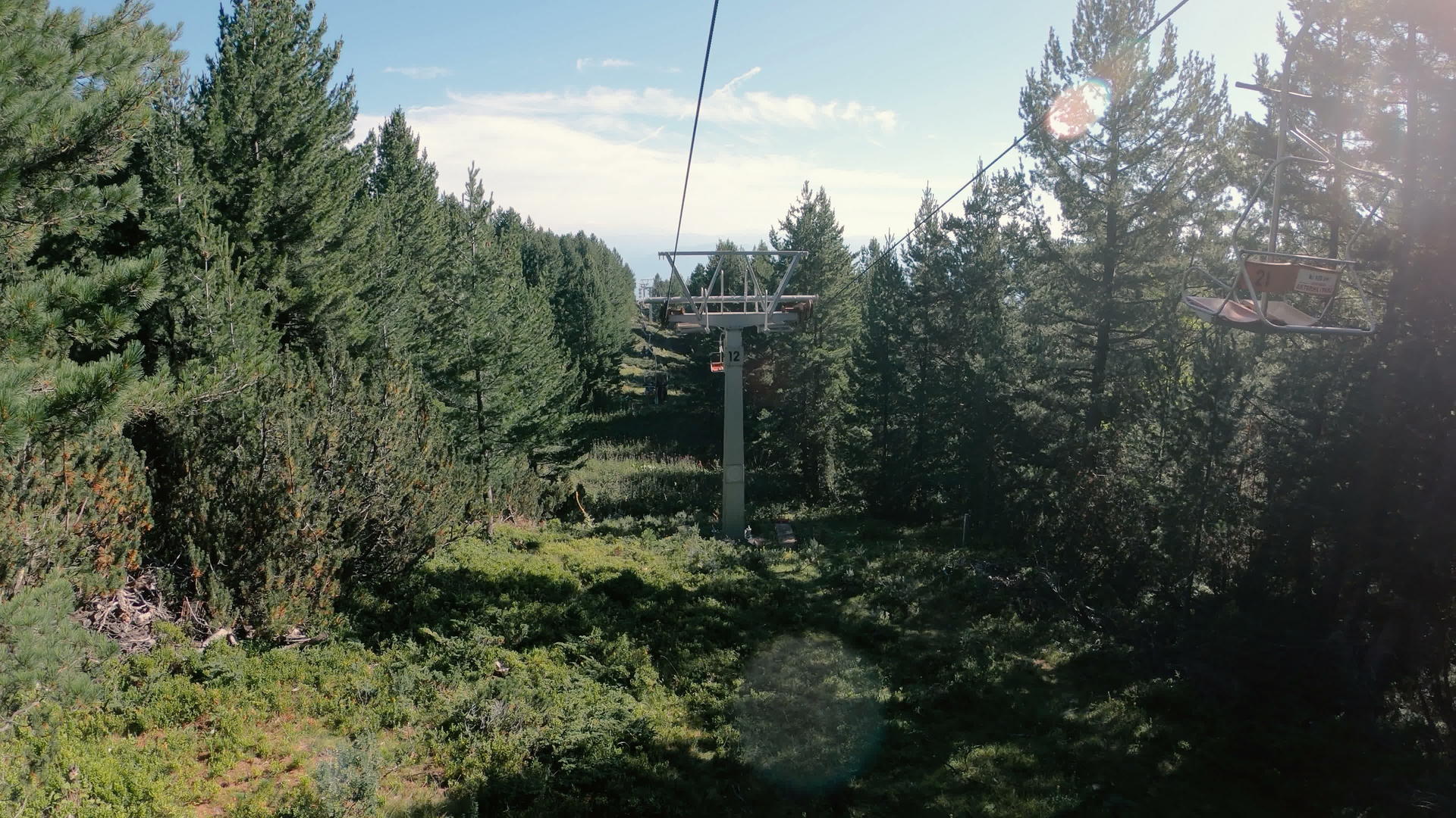 夏天禁酒滑雪胜地的空椅子升空穿过森林视频的预览图